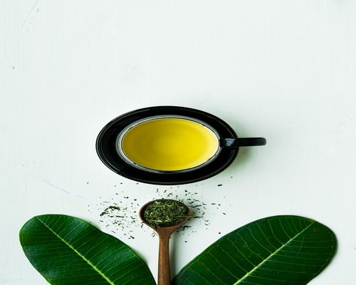 Aromatic green tea leaves and cup